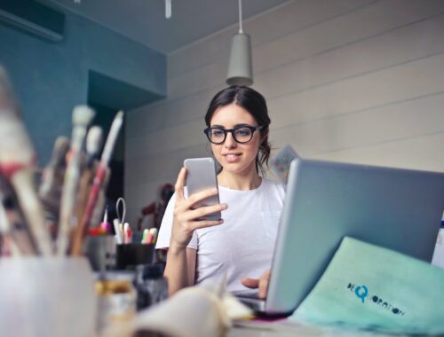 woman on her cellphone with art materials in the foreground