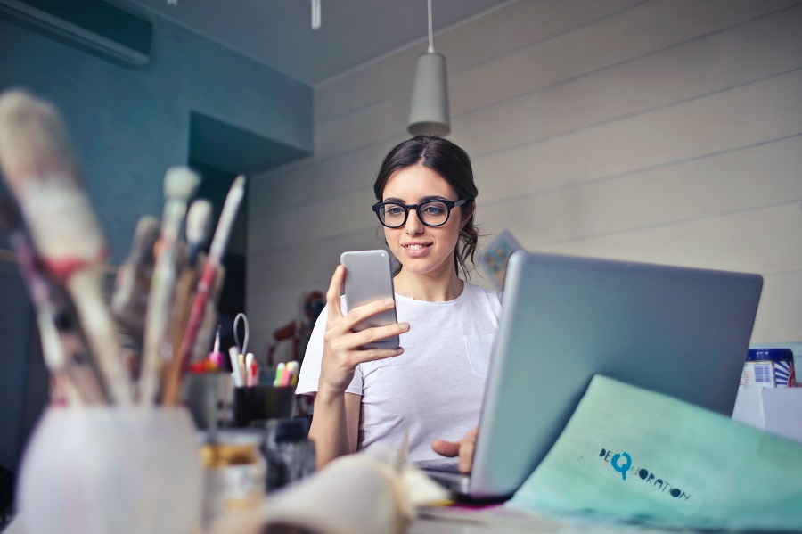 woman on her cellphone with art materials in the foreground